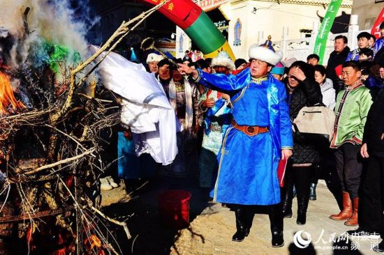 巴彦淖尔市磴口县，蒙古族群众把祭品洒向篝火。邢皓 摄