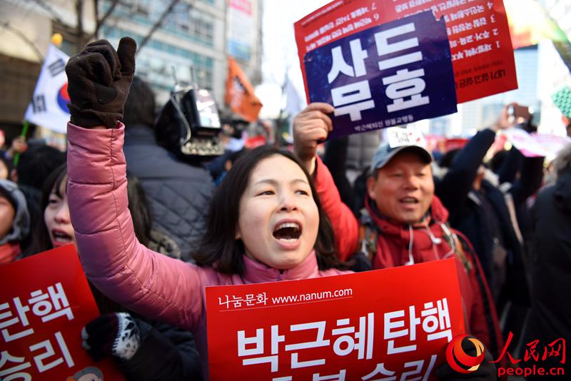 韩国民众在弹劾案通过后欢呼呐喊。裴埈基摄