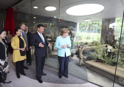 7月5日，国家主席习近平同德国总理默克尔共同出席柏林动物园大熊猫馆开馆仪式。这是习近平和夫人彭丽媛同默克尔在大熊猫馆。新华社记者 马占成 摄