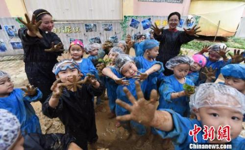 资料图：江西省新余市蓓蕾幼儿园大一班的孩子们在老师带领下抓泥鳅、打泥仗。　赵春亮 摄