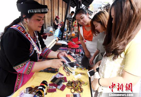 台湾少数民族手作文创艺术品吸引福州女青年眼球。　记者刘可耕 摄