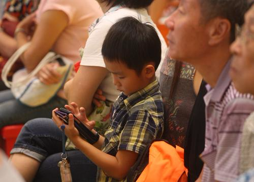 香港儿童沉迷用手机上网的情况恶化，有损健康亦不利家庭关系。图片来源：香港《大公报》。
