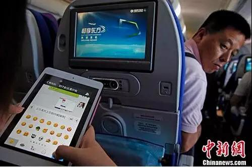 乘客在飞机上使用微信。图片来源 <span target='_blank' href='http://www.chinanews.com/' >中新网</span>