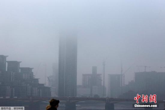 当地时间2016年10月31日，英国伦敦早上出现大雾天气。图为市民在雾中行走。
