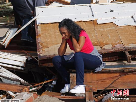 当地时间1月21日，美国密西西比州哈蒂斯堡遭遇龙卷风袭击，导致数人丧生，房屋、树木等受损严重。图为一名女子坐在自家房屋的废墟中。