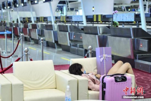 资料图：8月1日，深圳机场，一名旅客因航班取消在出发大厅内休息。<a target='_blank' href='http://www.chinanews.com/'></table>中新社</a>记者 陈骥旻 摄
