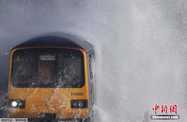 英国伦敦刮起强风巨浪 火车穿浪而出