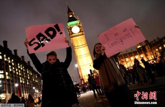 伦敦街头抗议的民众高举标语，反对特朗普的移民新政。