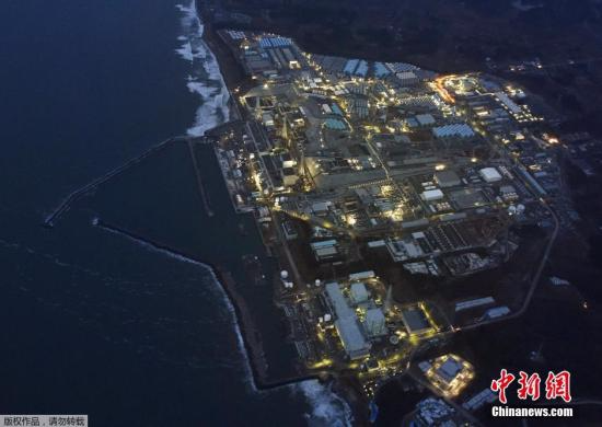 资料图：福岛第一核电站在黄昏中停运亮灯的场景。