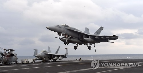 3月14日，F/A-18战斗机在“卡尔·文森”号核动力航母上降落。（图片来源：韩联社）