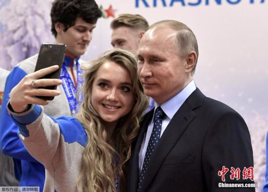 资料图：俄罗斯总统普京与运动员合影自拍。