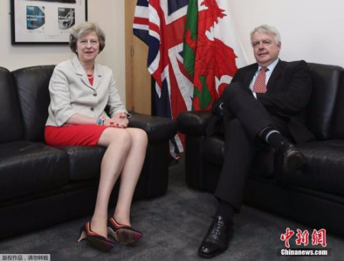 资料图：当地时间2016年7月18日，英国卡迪夫，英国新任首相特蕾莎·梅与威尔士第一大臣卡因·琼斯(Carwyn Jones)会面。特蕾莎·梅穿红色短裙配彩色手镯，一双大长腿十分抢镜。