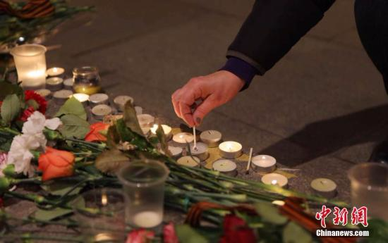 当地时间4月3日晚，俄罗斯民众在“先纳亚广场”地铁站前点燃蜡烛悼念地铁爆炸遇难者。王修君 摄