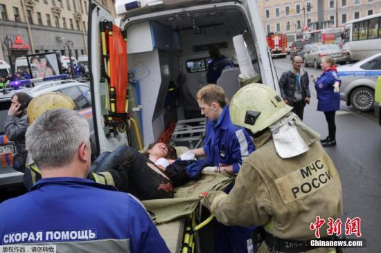 图为“先纳亚广场”地铁站爆炸事件的伤员被抬上救护车。