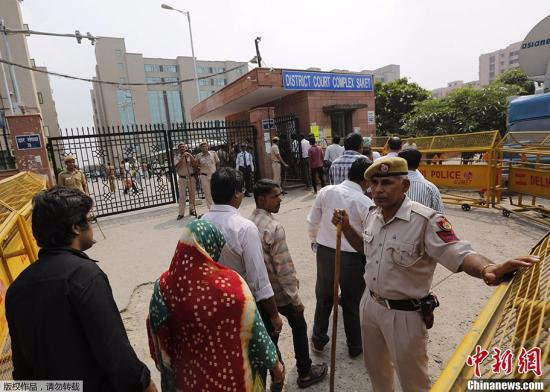 据外电报道，印度法官当地时间9月13日宣布，判处2012年12月新德里“黑公交”轮奸案4名成年被告死刑。图为旁听者排队通过安检进入法院。