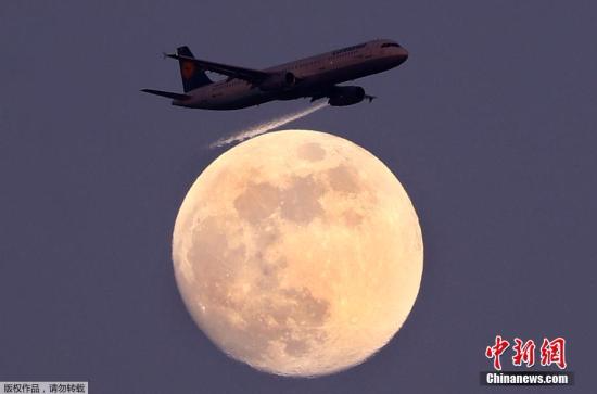 当地时间4月9日，在德国法兰克福，德国汉莎航空公司的一架客机从月亮前飞过。