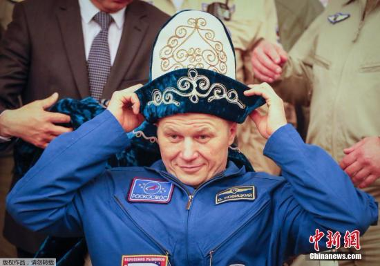 俄罗斯宇航员奥列格·诺维茨基戴上具有哈萨克斯坦民族特色的帽子。
