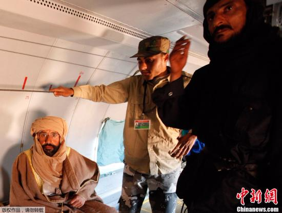 11月19日，在利比亚的津坦，卡扎菲次子赛义夫·伊斯兰·卡扎菲(左一)在一架飞机里。利比亚“全国过渡委员会”(过渡委)军方19日在的黎波里宣布，执政当局在利比亚南部塞卜哈地区成功抓获卡扎菲次子赛义夫·伊斯兰·卡扎菲。