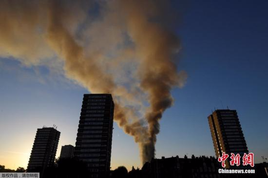 当地时间6月14日凌晨，伦敦西部一栋20余层的公寓大楼发生大火，火势猛烈，几乎蔓延到了所有楼层。约200名消防员和40辆消防车前往灭火。图为现场浓烟冲天。