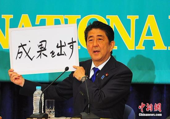 日本参议院选战在即，6月21日在日本记者俱乐部进行的选前党首辩论会上，“安倍经济学”的成败功过再度成为热辩之题。图为安倍现场高调亮出“搞出成果”字牌。<a target='_blank' href='http://www.chinanews.com/'></table>中新社</a>记者 王健 摄