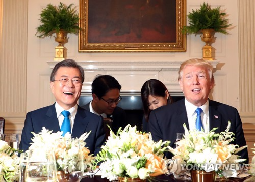资料图片：当地时间6月29日，在美国白宫，文在寅(左)和特朗普在晚宴上亲切对话。(韩联社)