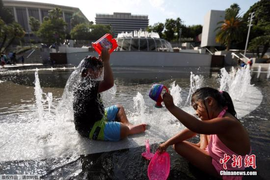 当地时间2017年7月6日，美国加州洛杉矶，儿童在喷泉戏水解暑。