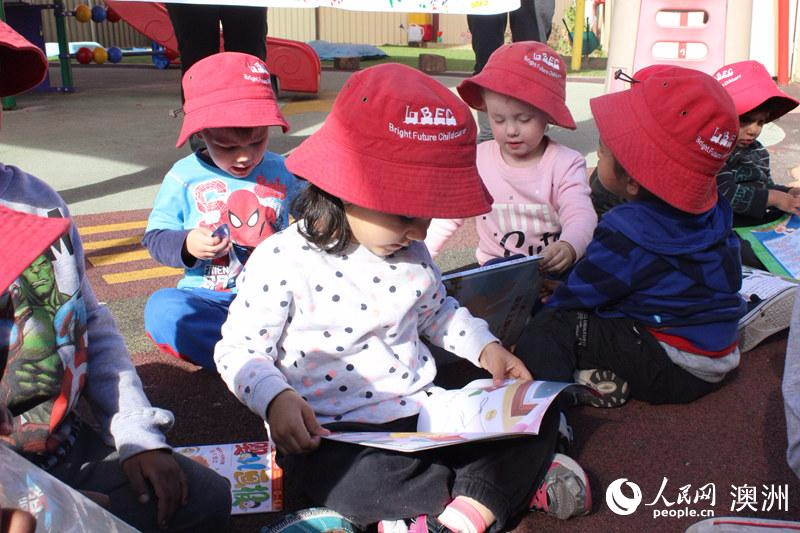 当地幼儿园学生认真阅读中国儿童书籍（摄影 王泉骄）