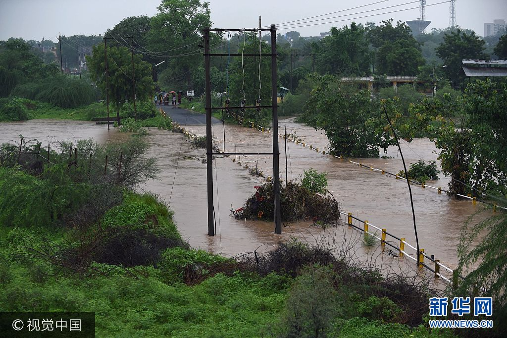 A submerged bridge is covered with flood waters near Vivekanandnagar village on the outskirts of Ahmedabad on July 26, 2017. The bodies of 25 people, including 17 members of a single family, were pulled from the mud on July 26 as the death toll from major flooding in India climbed towards 120, an official said. SAM PANTHAKY