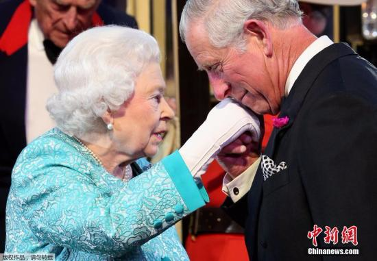 资料图：当地时间2016年5月16日，英国女王伊丽莎白二世在温莎城堡举行90岁生日庆典，当天女王身着蓝色套装一头银发精神矍铄，和丈夫菲利普亲王乘坐马车到底庆典现场。当天的庆典活动上除了有马术表演之外，现场还挂出了女王的结婚照。