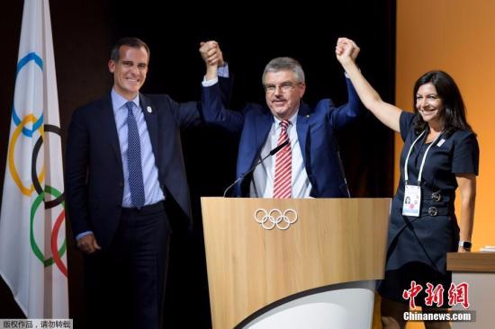 国际奥委会130届全会7月11日在瑞士洛桑举行投票，一致决定2024年和2028年夏季奥运会的承办城市将同时产生，现在唯一的悬念是两个申办城市洛杉矶和巴黎谁先举办。图为投票结束后，洛杉矶市长加塞蒂和巴黎市长伊达尔戈登上主席台，国际奥委会主席巴赫站在中间高举起两人的手表示庆祝。