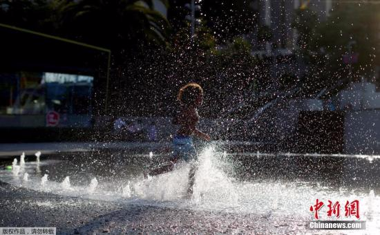 当地时间2017年7月6日，美国加州洛杉矶，儿童在喷泉戏水解暑。