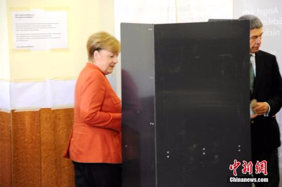 当地时间9月24日下午，德国总理默克尔在柏林洪堡大学的投票站参加大选投票。图为默克尔和丈夫绍尔在写票。<span target='_blank' href='http://www.chinanews.com/'></div>中新社</span>记者 彭大伟 摄