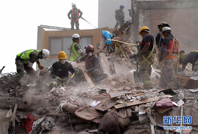 　9月25日，救援人员在墨西哥首都墨西哥城的一处地震废墟中搜寻。