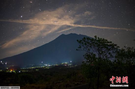 据外媒报道，巴厘岛阿贡火山周围地带近期地动频繁，随时可能爆发。距离印尼热门旅游地点库塔75公里的阿贡山从8月中旬开始活跃起来，可能出现50多年来的首次爆发，附近的9.6万多人已经撤离家园。印尼国家减灾署发言人苏托坡27日发布声明称，撤离者数目预计会继续上升。巴厘岛每年吸引数以百万计的外国游客到其美丽的海滩度假，阿贡山喷发将给依赖旅游业的巴厘岛经济带来冲击。一旦阿贡山喷发，印尼计划把要飞往巴厘岛的航班转往其他10个机场，包括附近的龙目岛和首都雅加达。图为夜空下的印尼阿贡火山。