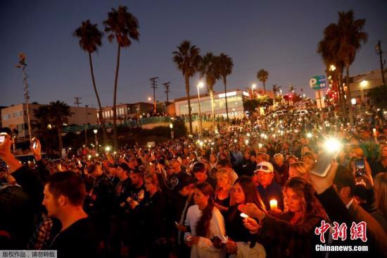 当地时间2017年10月4日，美国加州曼哈顿海滩，民众和遇难者的亲人朋友集会，手持烛光和灯光，悼念日前拉斯维加斯枪击案遇难者。
