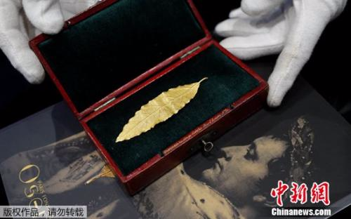 拍卖师展示一片黄金月桂叶，这片金叶子曾是拿破仑加冕礼皇冠上的几十片金叶子之一。