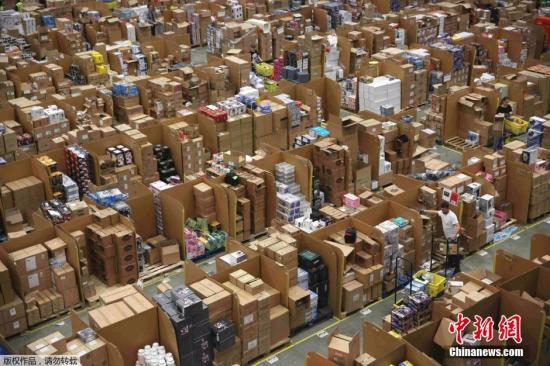 资料图：英国Hemel Hempstead的一处亚马逊仓库内，工作人员正忙着给商品装箱。