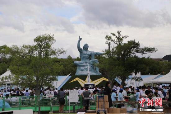 资料图：2014年8月9日，是日本长崎市遭遇原子弹爆炸69周年。当天，众多市民来到长崎市内的纪念地，参加纪念活动，祈愿和平。图为来到长崎和平公园内的和平祈念像前参加纪念活动的人们。 <a target='_blank' href='http://www.chinanews.com/'></table>中新社</a>发 高越 摄