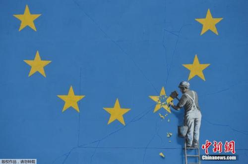 资料图：英国街头艺术家班克西创作了一幅画，画面中一名工人正从欧盟12星旗帜上抹掉一颗星，寓意着英国将脱离欧盟。