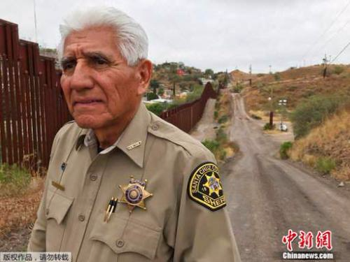 美国边境城镇的警察托尼•埃斯特拉达在美墨边境墙旁。