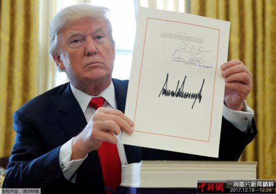 当地时间2017年12月22日，美国华盛顿，美国总统特朗普在白宫的椭圆形办公室签署1.5万亿美元税改法案，此乃美国最近逾30年来最大规模减税行动。