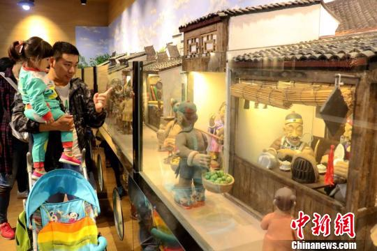 图为第三届中国大运河庙会上父亲带孩子观展 何蒋勇 摄