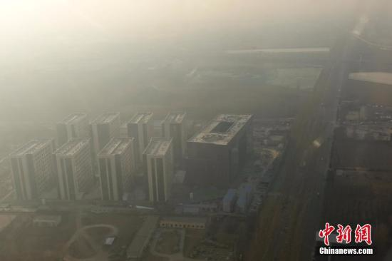 12月16日，透过飞机舷窗俯瞰北京，城市建筑隐在雾霾中。12月15日北京发布今年首个空气重污染红色预警：16日20时，北京市启动空气重污染红色预警。<span target='_blank' href='http://www.chinanews.com/'></div>中新社</span>记者 盛佳鹏 摄