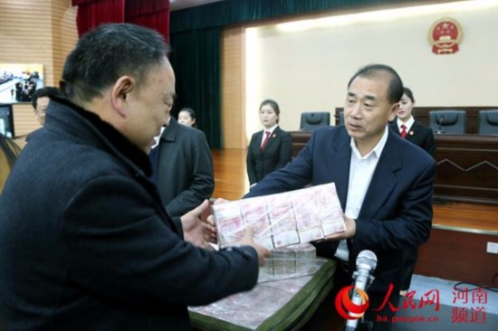 12月5日，河南洛阳市中级法院一号审判庭内，农民工代表拿到执行款3.9亿元。