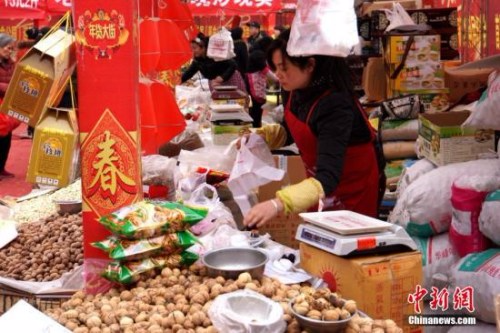 资料图：2015年2月5日，春节临近，西安的年货市场也开始“红火”起来，前来采购新年喜庆饰品、酒水饮料和食品的市民络绎不绝。张远 摄