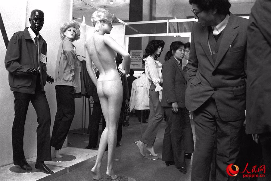 1988年，上海服装展上，一位中年人斜着眼睛偷瞄裸体塑料模特。