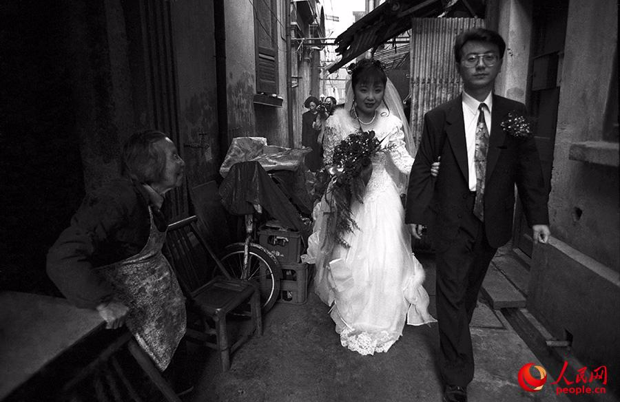 龚建华拍摄于1995年，从上海自忠路老弄堂里走出来一对新娘新郎。