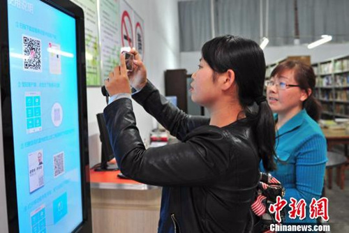 资料图：湖北省宜都市的市民在电子图书馆借阅终端上下载自己喜欢阅读的电子图书。曹礼达 摄