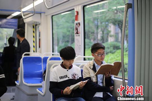 资料图：南京有轨电车里的“世界读书日”，市民在有轨电车上阅读书籍。　泱波 摄
