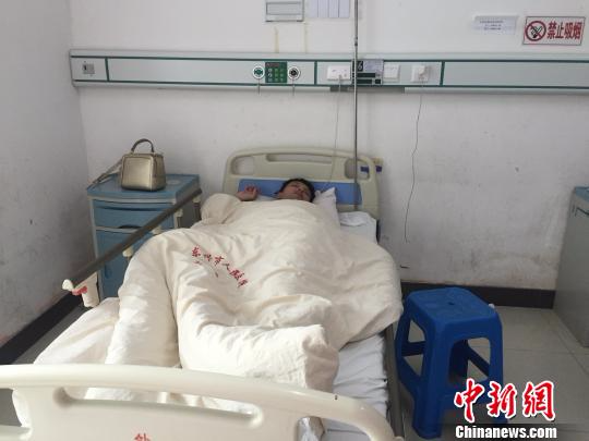2月12日，广西东兴市人民医院住院部病房内，遭越南边防人员殴打致伤的中国游客谢某躺在病床上。　陈燕 摄
